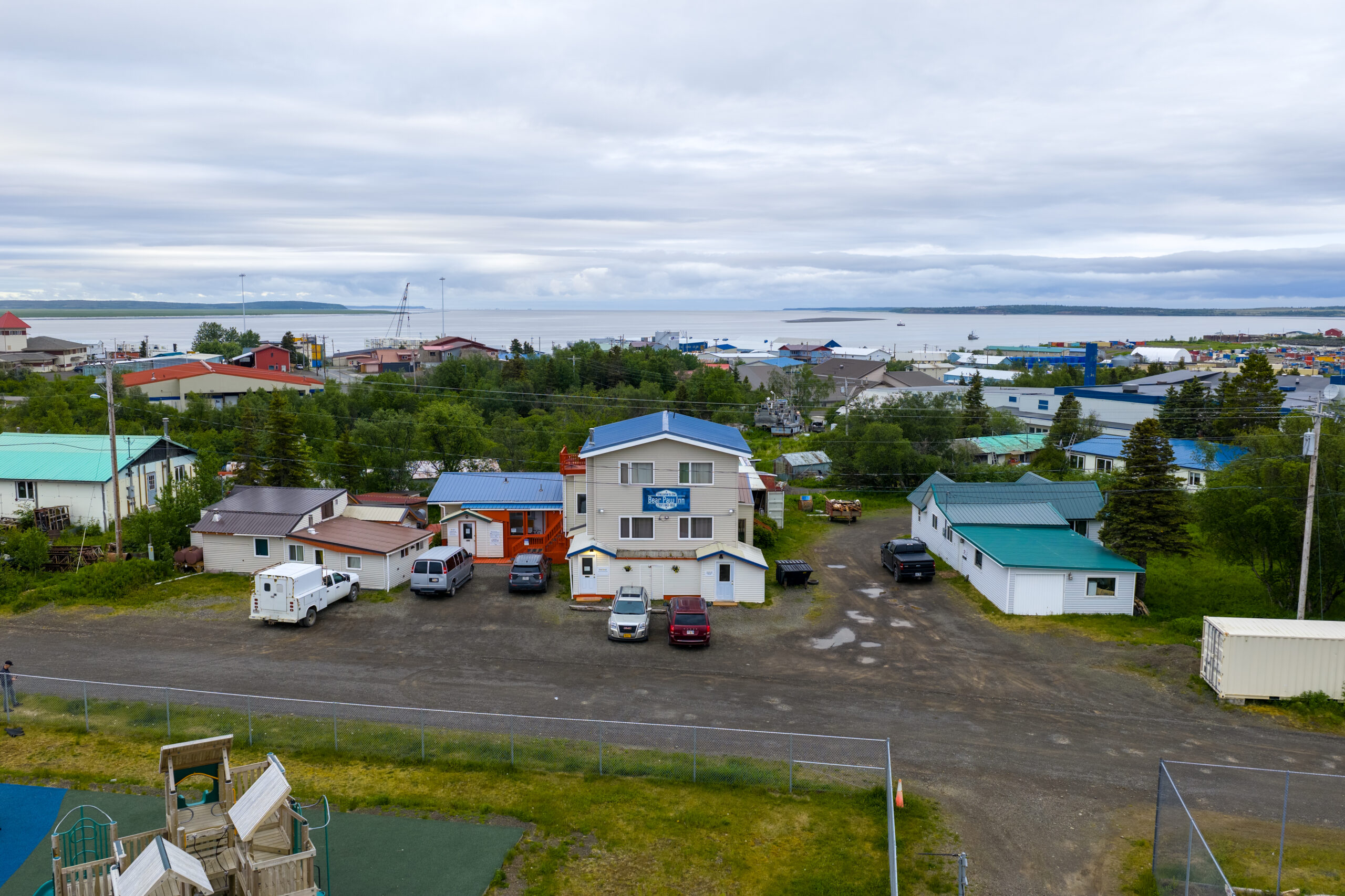 Aerial view of Bear Paw Inn and nearby houses with ocean and harbor in the background